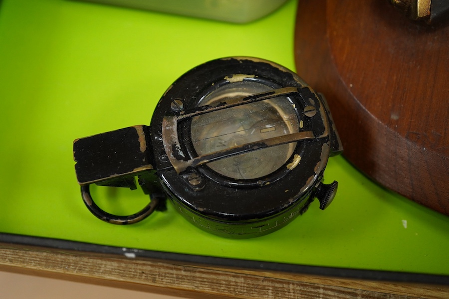 A collection of military items, including a U.S. Army helmet, an M42 helmet, a WWII British Home Front helmet, a Union flag 96cm x 60cm, a compass, a Kukri display shield, and a box of military cap badges, buttons, etc.